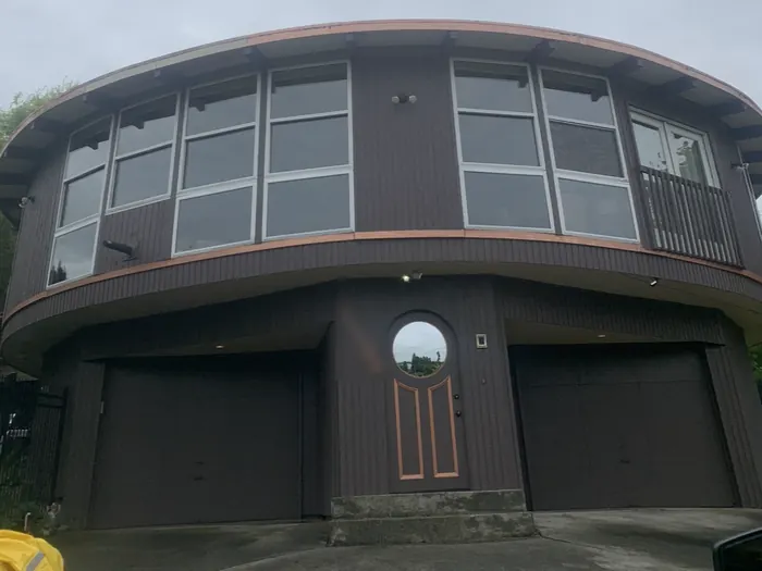 Round house before: faded brown siding with copper-colored trim